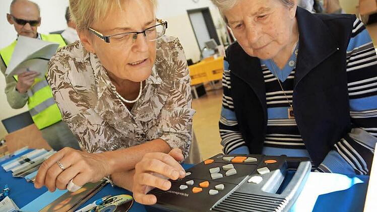 Kirsten Hüser-Nuß (links) erklärt einer Besucherin den Daisy-Player für spezielle Blinden-Hörbücher. Fotos: Arkadius Guzy