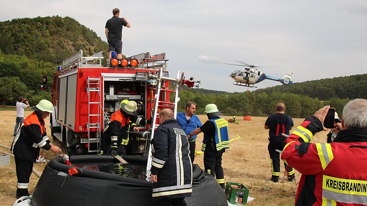 Besonders eng war das Zusammenspiel von Feuerwehr und Polizei beim Befüllen des Wassersacks am Polizeihubschrauber. Foto: Ralf Ruppert