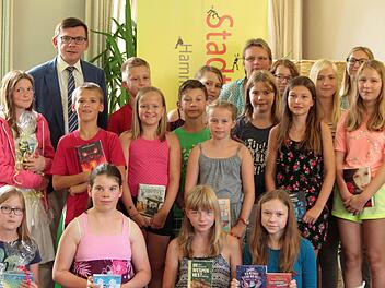 B&uuml;rgermeister Armin Warmuth gratulierte den Gewinnern, die bei der Verlosungsaktion der Stadtbibliothek Hammelburg gewonnen haben. Foto: Stadtbibliothek Hammelburg