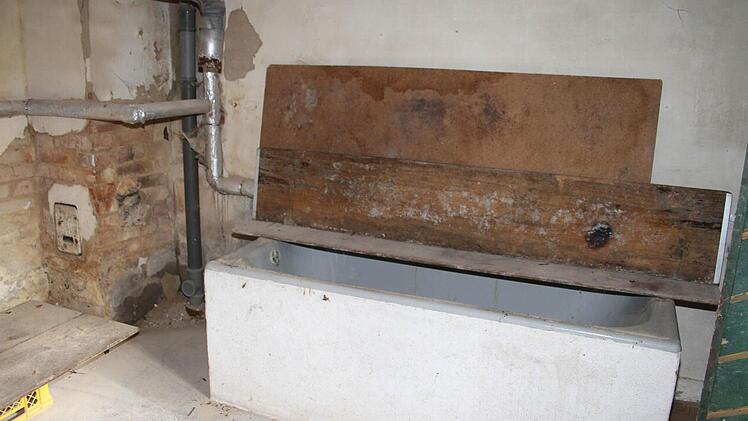 Natürlich gibt es ein Bad in den Baracken: Es ist nur von außen zugänglich, ist im Keller untergebracht. Der Holzofen, der nachdem Krieg in dem Kellerraum für Wärme sorgte, ist schon lange abmontiert, aber die Badewanne ist noch nutzbar, erklärt die Bewohnerin. Doch das Wasser müsste erwärmt werden, in die Badewanne geschöpft werden - im Winter ist das nicht machbar. Foto: Sonja Adam