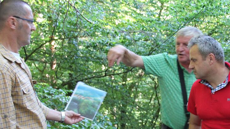 Uwe Werner von der Wandergruppe des Bürgervereins erfreut sich an der einst schönen Aussicht auf Jesserndorf, die ihm Heinz Fausten per Foto präsentiert, was Bernd Ebert auch interessiert (im Bild von links). Foto: Ralf Kestel