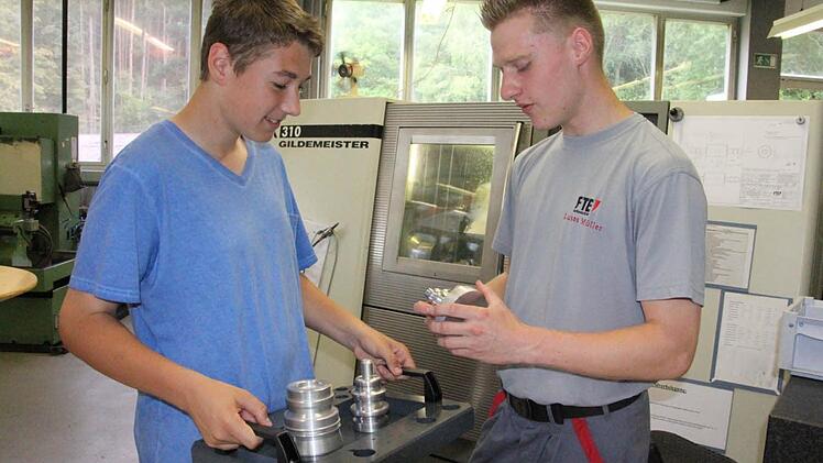 Julian Schneider aus Holzhausen (links) lässt sich von Azubi Lukas Müller (rechts) einige Werkstücke erklären. Foto: Helmut Will