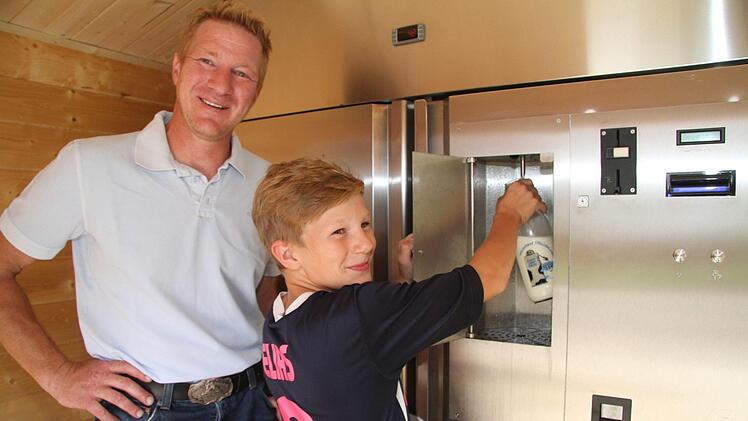 "Das funktioniert", probiert Elias (11) die Milchtankstelle aus - und Papa Markus Münch fällt ein Stein vom Herzen. Ab Freitag sind Milchtankstelle und Regio-Automat betriebsbereit. Foto: Sonny Adam