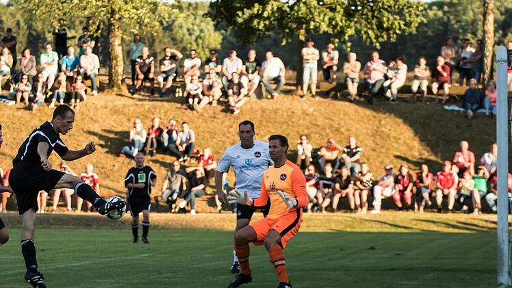Der Schuss des Kleukheimers Robert Schneiderbanger (am Ball) geht nur knapp am linken Pfosten des N&uuml;rnberger Tores vorbei. Im Hintergrund die gut gef&uuml;llten R&auml;nge im Kleukheimer Stadion. Fotos: Hartmut Klamm