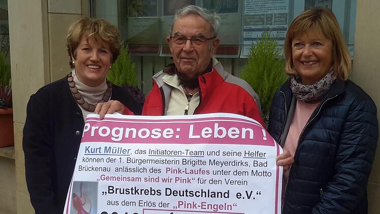 Kurt Müller (Bildmitte) hat beim Pinklauf wieder  Holzengel verkauft. Der Erlös geht an den Verein Brustkrebs Deutschland. Für die Spende bedankten sich Bad Brückenaus Bürgermeisterin Brigitte Meyerdierks (links) und Organisatorin Karin Bauer (rechts). Foto: Rolf Pralle