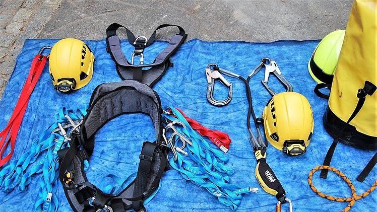 Dies alles gehört zum Gerätesatz "Absturzsicherung": (von links) 1,50 Meter lange Bandschlinge mit Tri-Lock-Karabinerhaken, Helm mit Leuchte, Auffang- und Sitzgurt mit 80 Zentimeter langen Bandschlingen, Ypsilon-Schlinge mit zwei Rohrhaken und Bandfalldämpfer (unten), Gerätesack und Kernmanteldynamikseil zur Sicherung vom Boden aus.Sigismund von Dobschütz