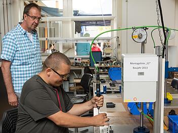 Bereichsleiter Gerd Bieber (links) führte beim Sommerfest durch die Werkstatt der Lebenshilfe in Nüdlingen. Mitarbeiter Thomas Rack zeigte, was hier produziert wird. Foto: Björn Hein