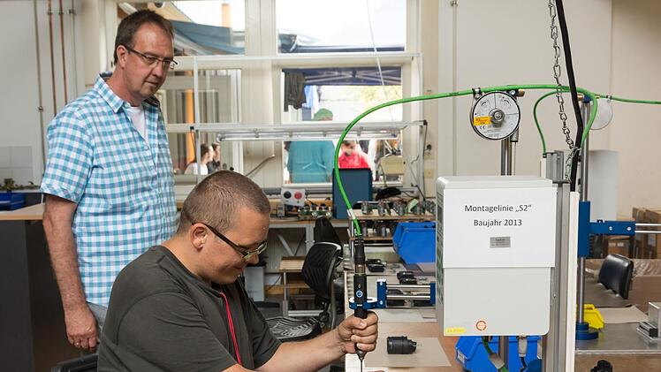 Bereichsleiter Gerd Bieber (links) führte beim Sommerfest durch die Werkstatt der Lebenshilfe in Nüdlingen. Mitarbeiter Thomas Rack zeigte, was hier produziert wird. Foto: Björn Hein