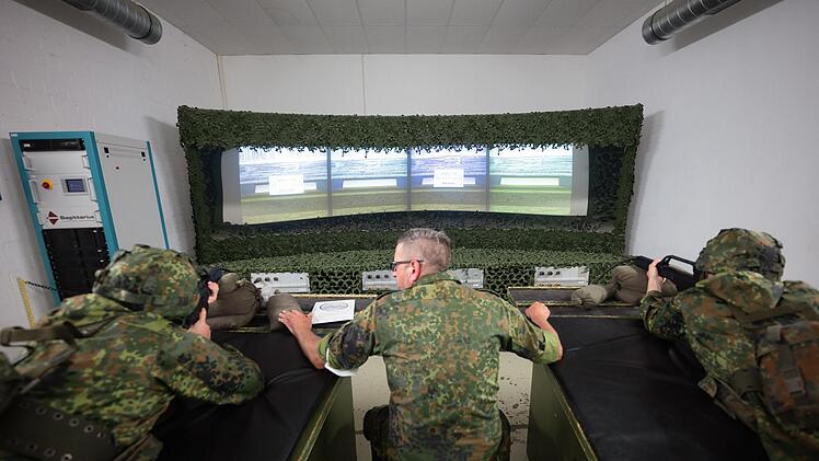 Ein Ausbilder der Bundeswehr spricht während eines Ausbildungsmoduls des Projektes "Ungediente für die Reserve" des Landeskommandos Hessen auf dem Truppenübungsplatz Hammelburg im Schießsimulator AGSHP (Ausbildungsgerät Schießsimulator Handwaffen/Panzerabwehrhandwaffen) mit zwei Reservisten in Ausbildung.
