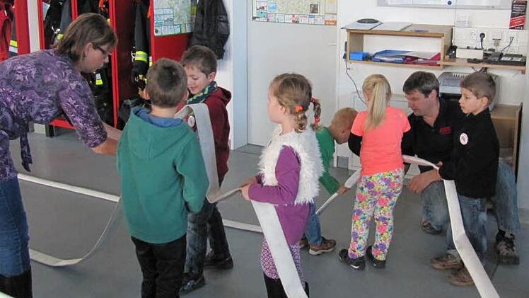 In der Fahrzeughalle zeigten Jochen und Manuela Bargel den Kindern erste Übungen und Spiele mit dem Schlauch.