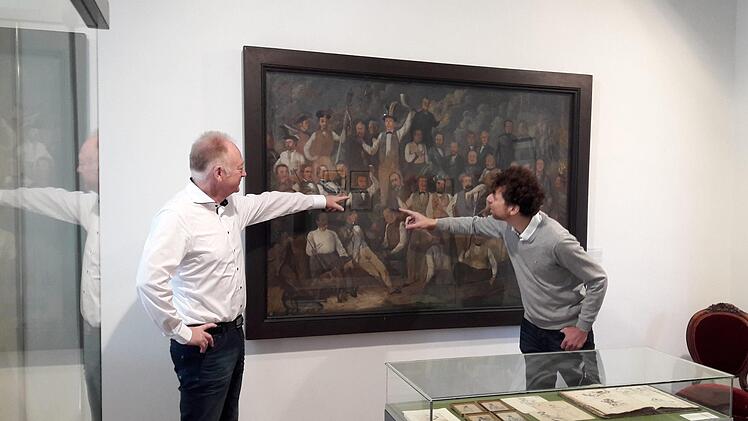 Die Reichstruppen, ein Geselligkeitsverein in Münnerstadt, gemalt von  Ignaz Bals. Bürgermeister und Museumsleiter zeigen das Selbstportrait  des Künstlers.Hartmut Hessel