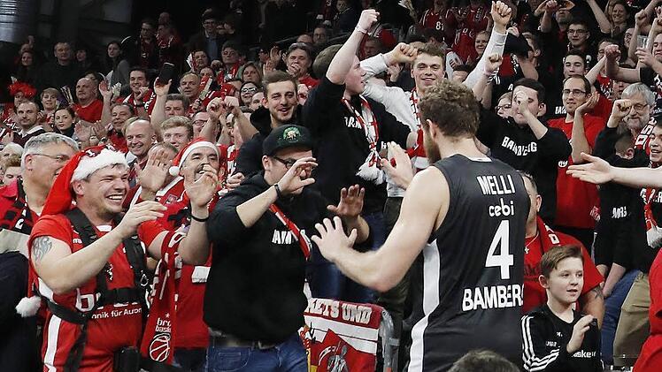 Nicolo Melli feiert mit den begeisterten Fans den Sieg über Olympiakos Piräus. Foto: Daniel Löb