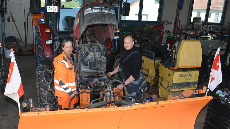 Robert Müller (rechts) wartet den Traktor, der beim Winterdienst der Stadt Münnerstadt im Einsatz ist. Oliver Büttner (links) ist dort einer der Fahrer. Björn Hein