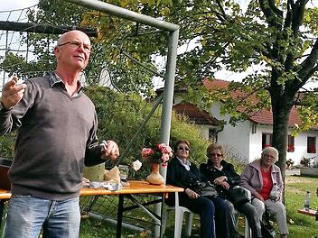 Werner Beck erläutert den Besuchern die richtige Behandlung von Rosen im Herbst.  Foto: Andreas Lomb