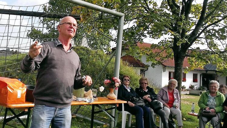 Werner Beck erläutert den Besuchern die richtige Behandlung von Rosen im Herbst.  Foto: Andreas Lomb