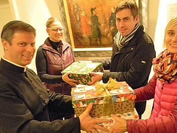 Pfarrer Matthias Steffel (l.) und Pfarrsekretärin Sonja Sawinsky (r.) nehmen die Pakete entgegen. Auch Hallerndorfs Bürgermeister Torsten Gunselmann (2. v. r.) brachte ein Paket vorbei.  Foto: Sonja Lengenfelder