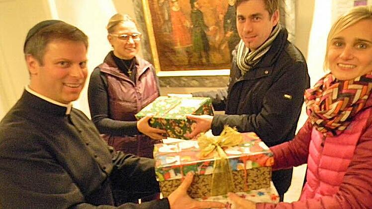Pfarrer Matthias Steffel (l.) und Pfarrsekretärin Sonja Sawinsky (r.) nehmen die Pakete entgegen. Auch Hallerndorfs Bürgermeister Torsten Gunselmann (2. v. r.) brachte ein Paket vorbei.  Foto: Sonja Lengenfelder