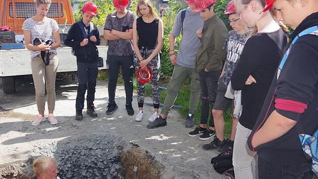 ASK-Rohrleger Christoph Feulner erkl&auml;rt aus der Tiefe die einzelnen Arbeitsschritte f&uuml;r die Erstellung eines Hausanschlusses.  Heike Sch&uuml;lein