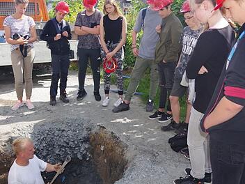 ASK-Rohrleger Christoph Feulner erkl&auml;rt aus der Tiefe die einzelnen Arbeitsschritte f&uuml;r die Erstellung eines Hausanschlusses.  Heike Sch&uuml;lein