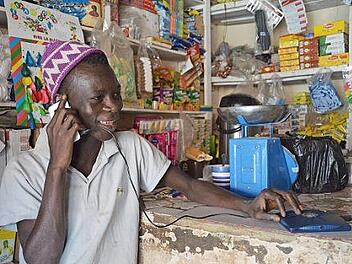 Ein Mann im Senegal lädt sein Handy mit einem Little-Sun-Gerät auf. Foto: Little Sun/dpa