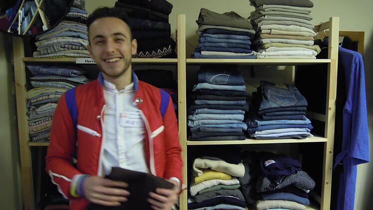 Helal Abdulghani sortiert Hosen im Kramlädchen. Foto: Julia Raab