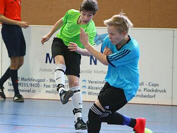 Niklas Hagen von der JFG Oberland schießt beim eigenen Hallenturnier in Marktleugast auf das Tor der JFG Schiefe Ebene (rechts Michi Schuler). In der neuen Saison treten die Talente der JFG Oberland wieder unter dem Namen ihrer Heimatvereine an.  Foto: Monika Limmer