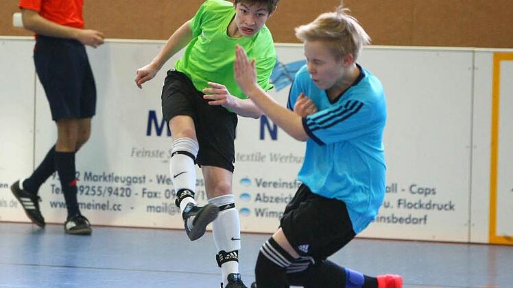 Niklas Hagen von der JFG Oberland schießt beim eigenen Hallenturnier in Marktleugast auf das Tor der JFG Schiefe Ebene (rechts Michi Schuler). In der neuen Saison treten die Talente der JFG Oberland wieder unter dem Namen ihrer Heimatvereine an.  Foto: Monika Limmer