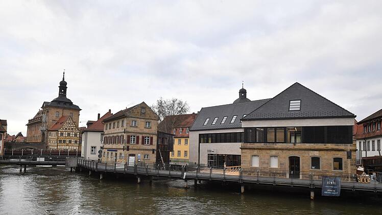 Der Neubau der Unteren Mühlen (rechts) liegt mitten in der Regnitz in Sichtweite zum Alten Rathaus in Bamberg. Foto: Ronald Rinklef