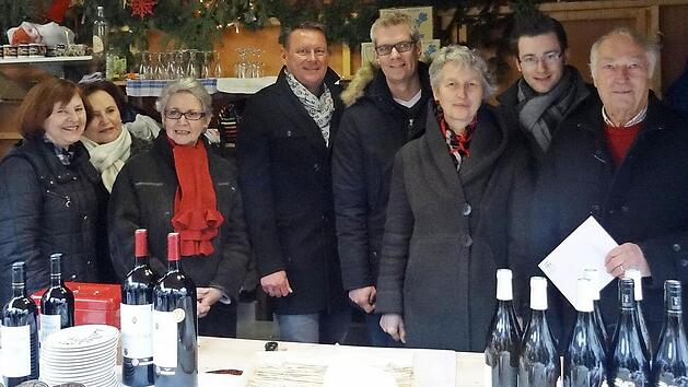 Forchheimer und ihre franz&ouml;sischen Besucher freuen sich, dass der Champagnerverkauf auf dem Weihnachtsmarkt in Forchheim so gut lief. Das brachte eine gro&szlig;e Spende f&uuml;r den sozialpsychiatrischen Dienst "Die Insel" ein. Foto: red
