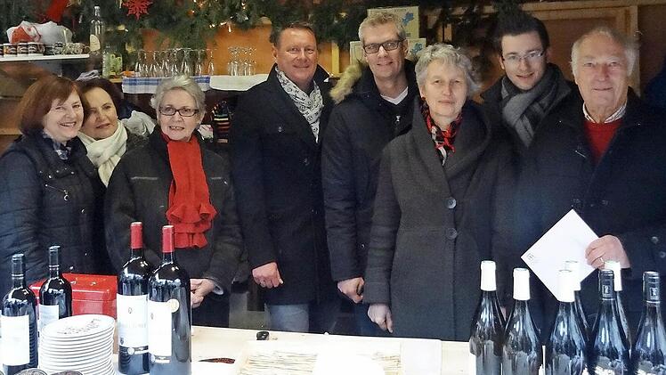 Forchheimer und ihre franz&ouml;sischen Besucher freuen sich, dass der Champagnerverkauf auf dem Weihnachtsmarkt in Forchheim so gut lief. Das brachte eine gro&szlig;e Spende f&uuml;r den sozialpsychiatrischen Dienst "Die Insel" ein. Foto: red