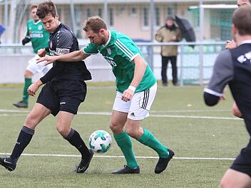 Der Sander André Karmann (grünes Trikot) im Zweikampf mit dem Würzburger Kapitän Moritz Lotzen