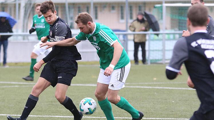 Der Sander André Karmann (grünes Trikot) im Zweikampf mit dem Würzburger Kapitän Moritz Lotzen