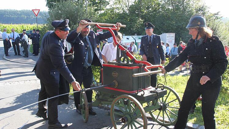 Wasser marsch: Die Freiwillige Feuerwehr Wüstenbuchau-Bechtelsreuth brachte zum Festzug in Rothwind ihre historische Spritze aus dem Jahre 1885 mit. Und Kommandantin Andrea Pfadenhauer-Wagner (rechts) streifte sich sogar eine alte Uniform aus der Zeit um 1900 über. Foto: Stephan Stöckel