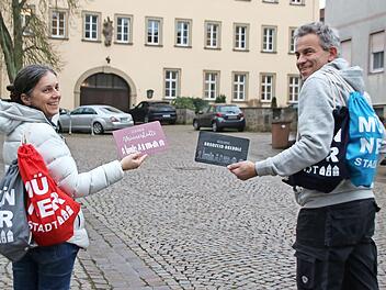 Christine Schikora und Arno Reuscher präsentieren die Rucksäcke und Frühstücksbrettchen des Gewerbevereins.