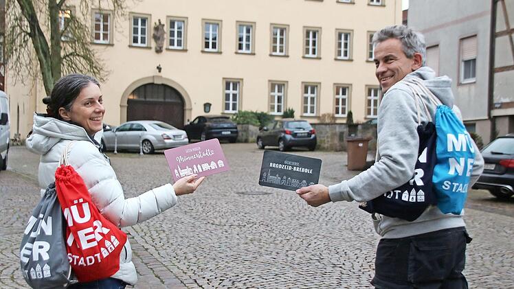 Christine Schikora und Arno Reuscher präsentieren die Rucksäcke und Frühstücksbrettchen des Gewerbevereins.