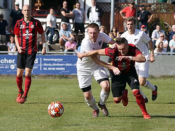 Der He&szlig;dorfer Dreifach-Torsch&uuml;tze Christian Merckel (rechts) liefert sich ein Laufduell mit R&ouml;ttenbachs Daniel Schulz. Foto: Sportfoto Zink