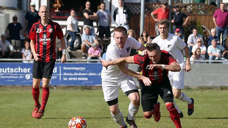 Der He&szlig;dorfer Dreifach-Torsch&uuml;tze Christian Merckel (rechts) liefert sich ein Laufduell mit R&ouml;ttenbachs Daniel Schulz. Foto: Sportfoto Zink