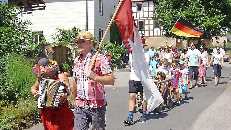 Das Kinderfest in Hellingen begann mit einem Umzug durch das Dorf, den Gabi Schirber musikalisch mit dem Schifferklavier und Frank Slawik mit der Fahne anführten. Foto: Gerold Snater
