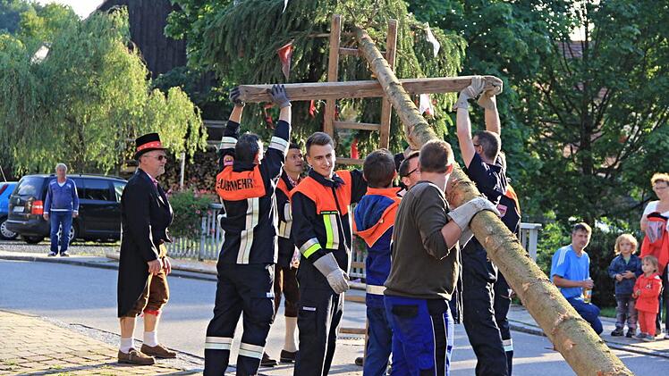 Feuerwehr und Dorfjugend stellte den Kirchweihbaum, eine etwa 15 Meter lange Fichte, am Freitagabend in der Dorfmitte am Feuerwehrgerätehaus auf. Fotos: Helmut Will