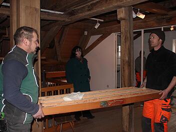 Sven Schneider (rechts) und Stefan Mützel tragen Teile aus dem Dachgeschoss nach unten. Das Ausräumen auf dem Dachboden erfolgt nach Absprache mit Projektleiterin Dr. Adina Rösch (im Hintergrund).