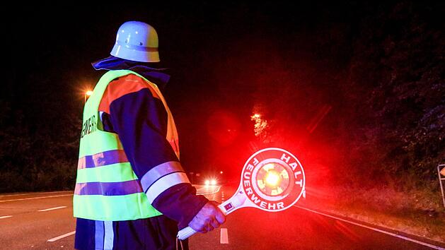 Ein  Feuerwehrmann sichert den Einsatzort  am Sonntag in Stegaurach ab.  Foto: News 5/Merzbach