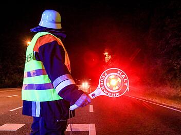 Ein  Feuerwehrmann sichert den Einsatzort  am Sonntag in Stegaurach ab.  Foto: News 5/Merzbach