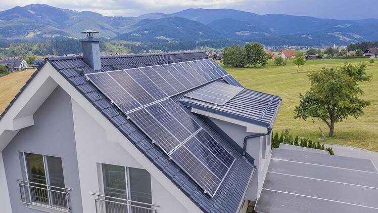 High angle shot of a private house situated in a valley with solar panels on the roof