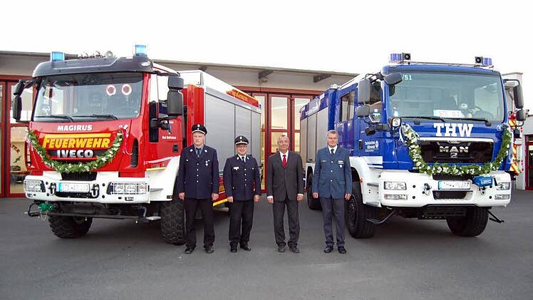 Die beiden Fahrzeuge von Feuerwehr und THW vor dem Feuerwehrhaus in Bad Staffelstein mit (von links) Kommandant Michael Ludwig, Kreisbrandrat Timm Vogler, Bürgermeister Jürgen Kohmann und THW Beauftragtem Manfred Pelkner. Foto: Andreas Welz