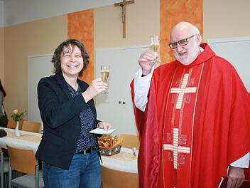 Pfarrgemeinderatsvorsitzende Regina Kirchner stößt mit Pfarrer Stephan Hartmann auf die Sebastianus Stube an, die jetzt in der neuen alten Schule eingeweiht wurde. Foto: Gabriele Sell