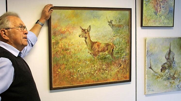 Bürgervereinsvorsitzender Ingo Hafenecker zeigt drei der 40 Bilder des Jagdmalers Willi Schütz, die ind er Galerie aus dem Fundus von 420 Gemälden präsentiert werden. Foto: Ralf Kestel