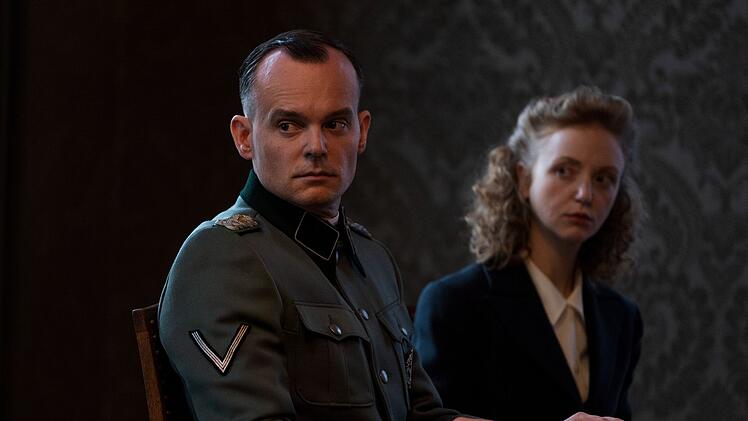 Die nur etwa 90 Minuten dauernde Konferenz "mit anschlie&szlig;endem Fr&uuml;hst&uuml;ck" beginnt: Adolf Eichmann (Johannes Allmayer) und Protokollantin Ingeburg Werlemann (Lilli Fichtner) sind mit dabei.