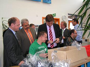 Ein Mitarbeiter zeigt beim Rundgang das Verpacken von WC-Rohren. Im Bild (von links) MdL Michael Hofmann, Bürgermeister Gerhard Amon, Landrat Hermann Ulm und Altlandrat Reinhard Glauber Foto: Heidi Amon