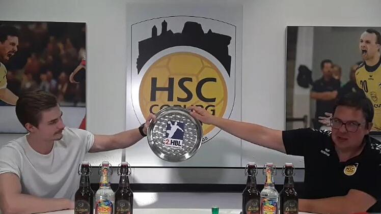 Meisterfeier einmal anders: Jakob Knauer (links) zeigt mit Thomas Apfel die Meisterschale. Mit einem Facebook-Live-Video feierte der Zweitliga-Meister HSC 2000 Coburg den Aufstieg in die Bundesliga.  Foto: Screenshot/Facebook