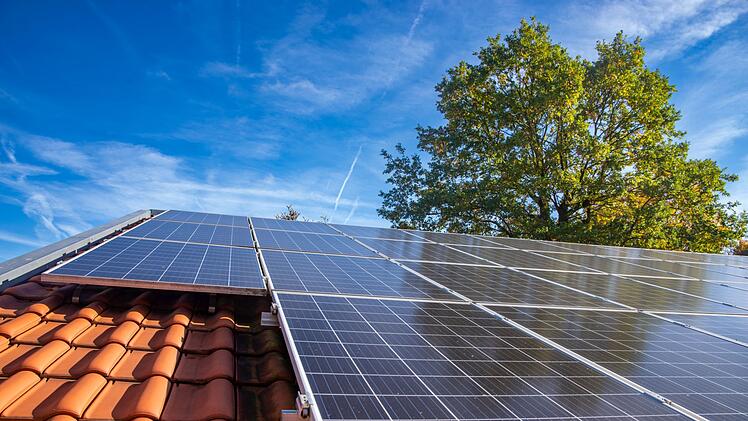Wet photovoltaic modules in front of blue and cloudy autumn sky